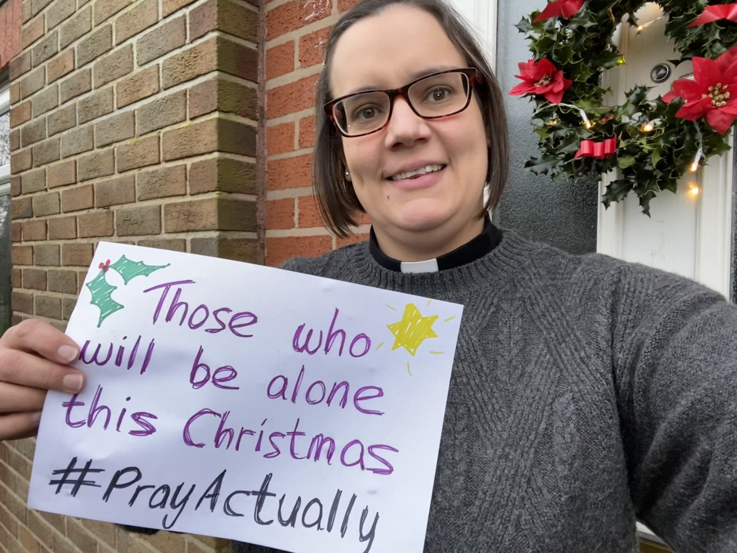 Revd Katy Cunliffe holding #prayactually sign